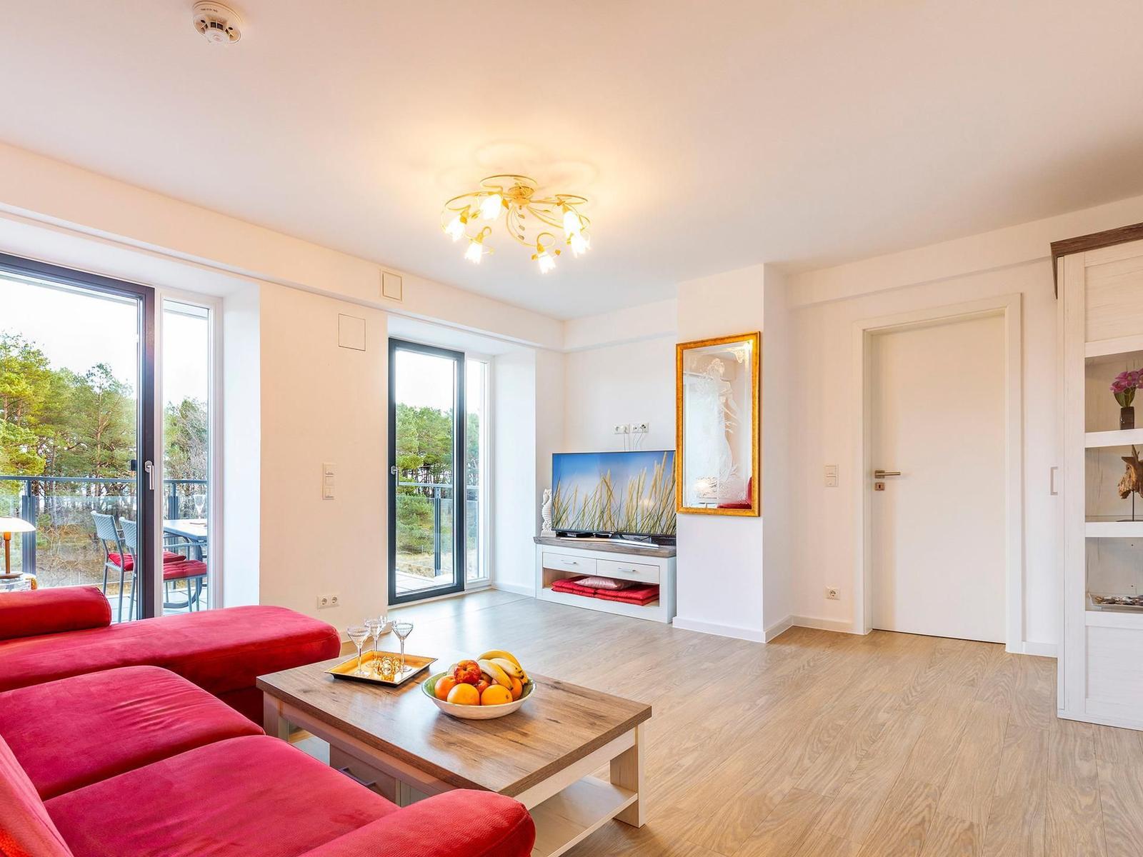 Wohnzimmer: Couch, TV, Essbereich, Zugang zum Balkon