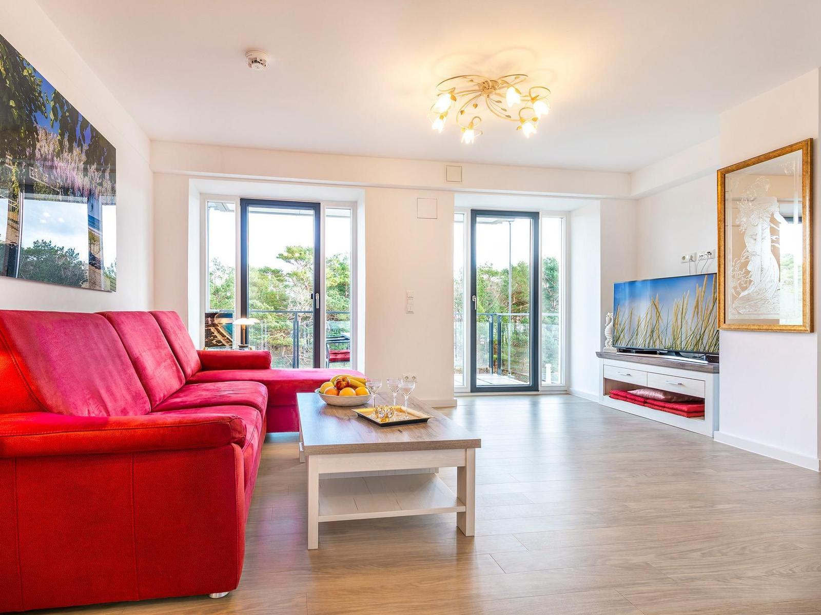 Wohnzimmer: Couch, TV, Essbereich, Zugang zum Balkon