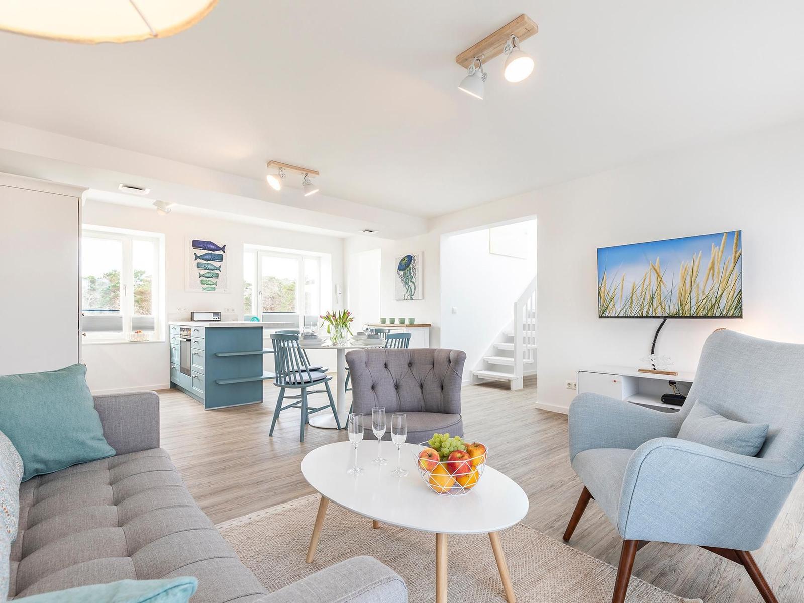 Wohnzimmer: Sofa, TV, Zugang zum Balkon und Dachterrasse