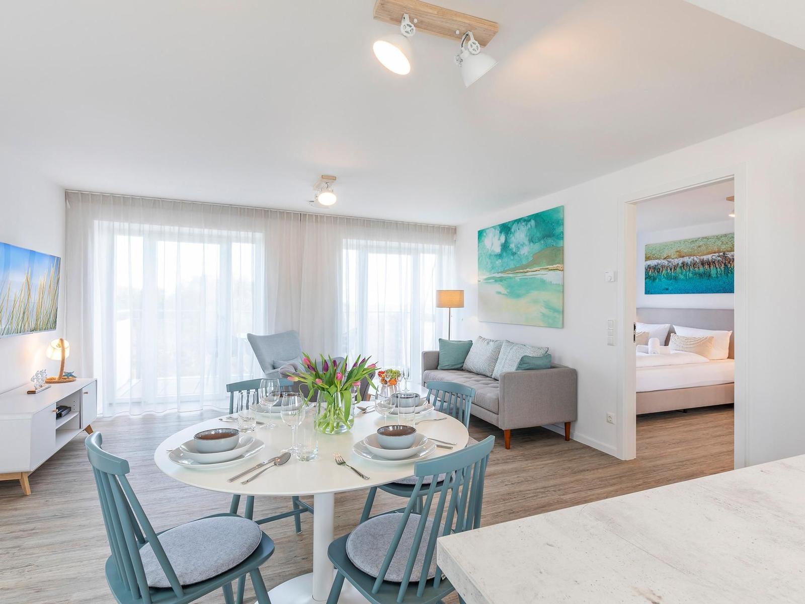 Wohnzimmer: Sofa, TV, Zugang zum Balkon und Dachterrasse