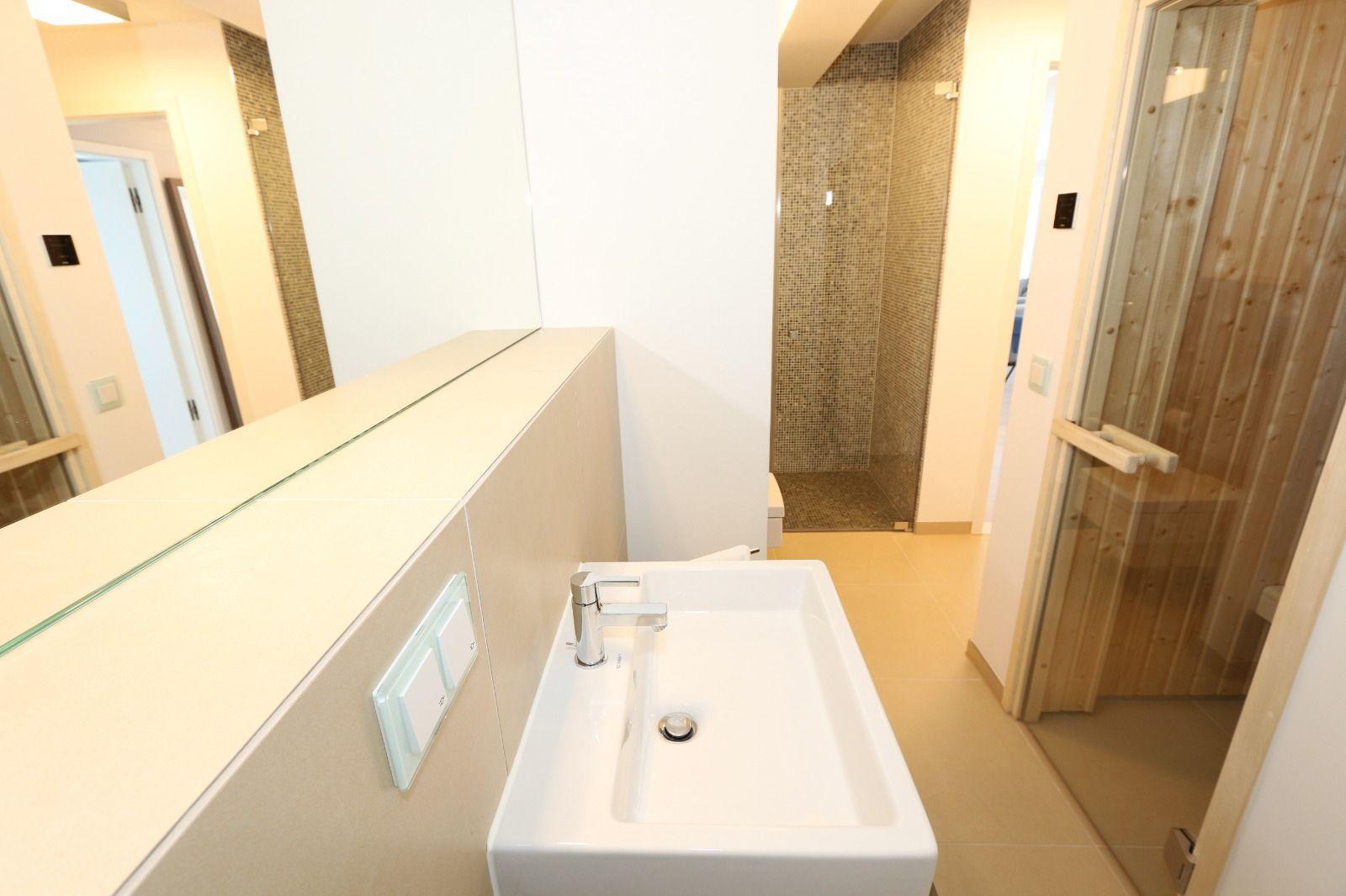 Badezimmer mit Waschbecken, Spiegel und Dusche