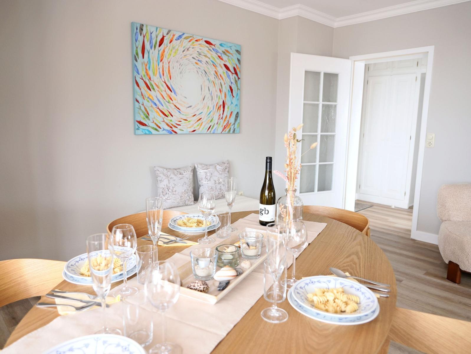Rundes Esszimmer mit Tisch, Stühlen und Wandbild