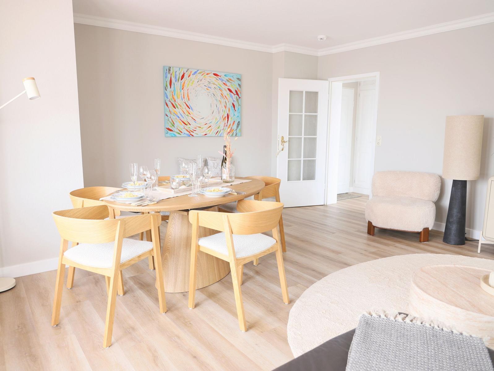 Esszimmer mit runden Tisch und Stühlen, Wandbild und Sitzgelegenheit