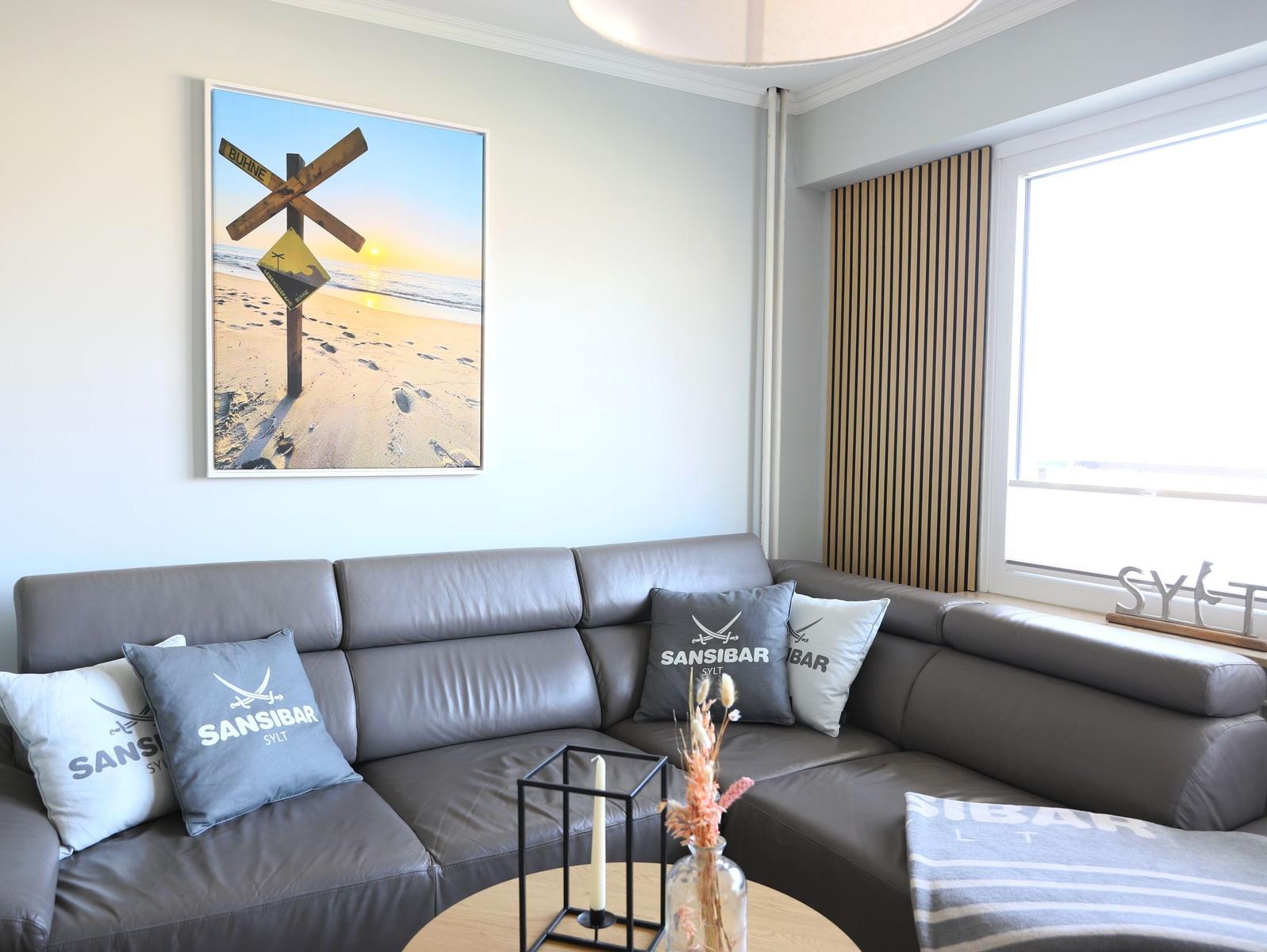 Grauer Sofa mit Kissen und Wandbild an der Wand.