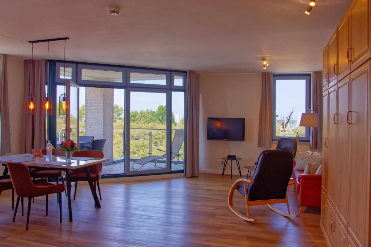 Wohn- und Essbereich mit Balkon, TV und Holzboden