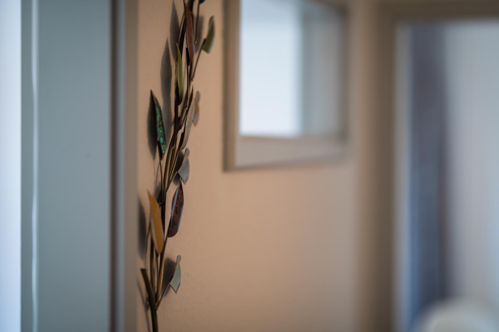 Wanddekoration mit metallischen Blättern an einer Wand