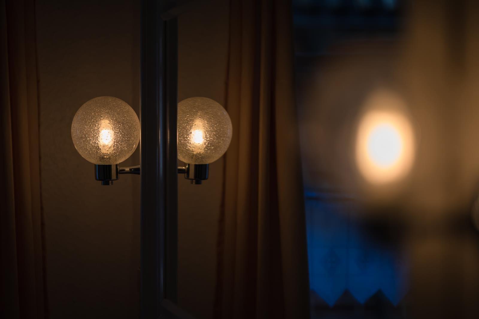 Zwei runde Lampen mit Textur reflektieren sich in einem Spiegel.