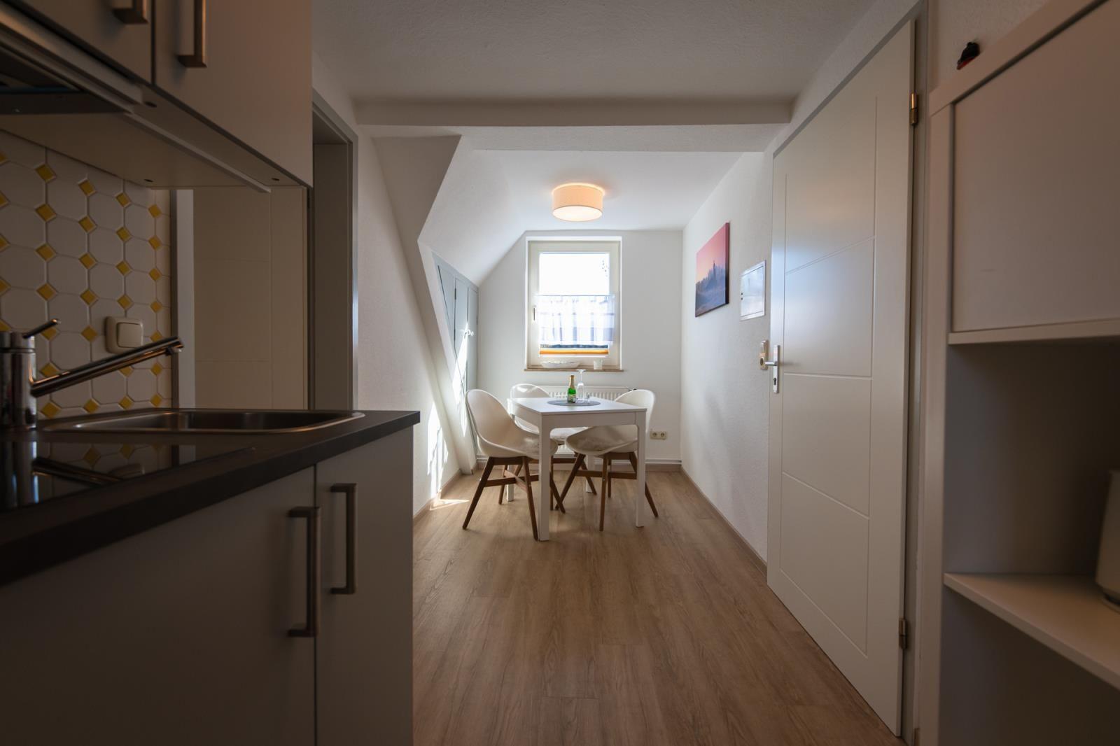 Kitchen with dining area, wooden floor, and window