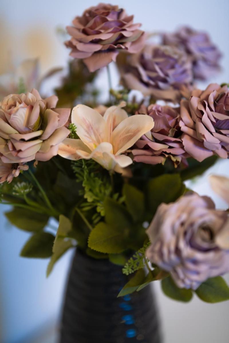 Blumenstrauß mit Rosen und Lilien in einem dunklen Vasen