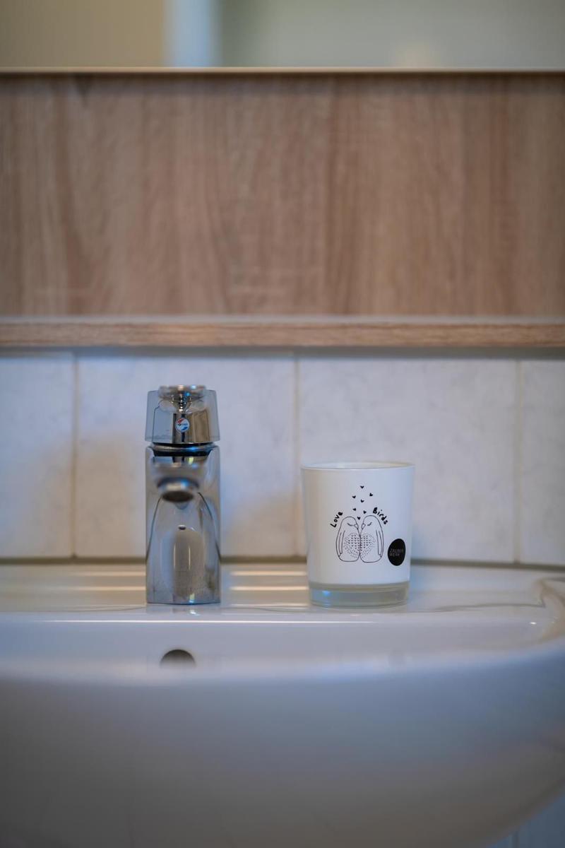 Waschbecken mit Wasserhahn und Tasse mit Motiv