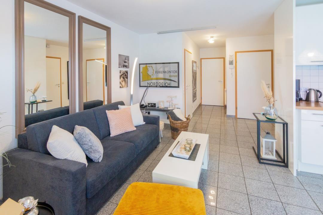 Living room with sofa, coffee table, and view into the kitchen