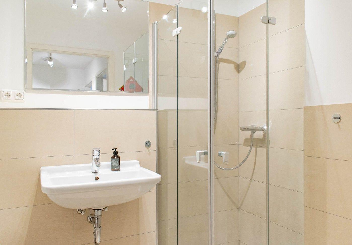 Bad mit Dusche, Waschbecken und Spiegel