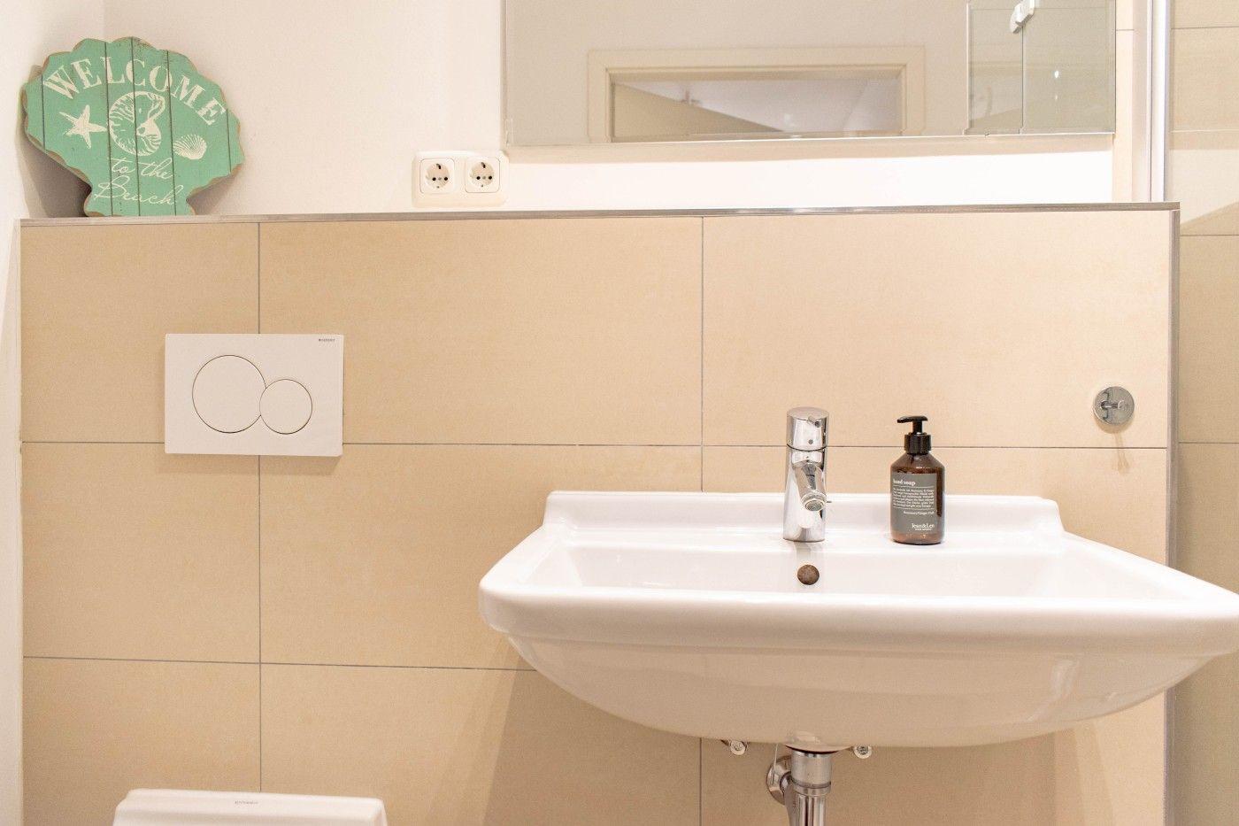 Badezimmer mit Waschbecken, Spiegel und Seebad-Dekoration.