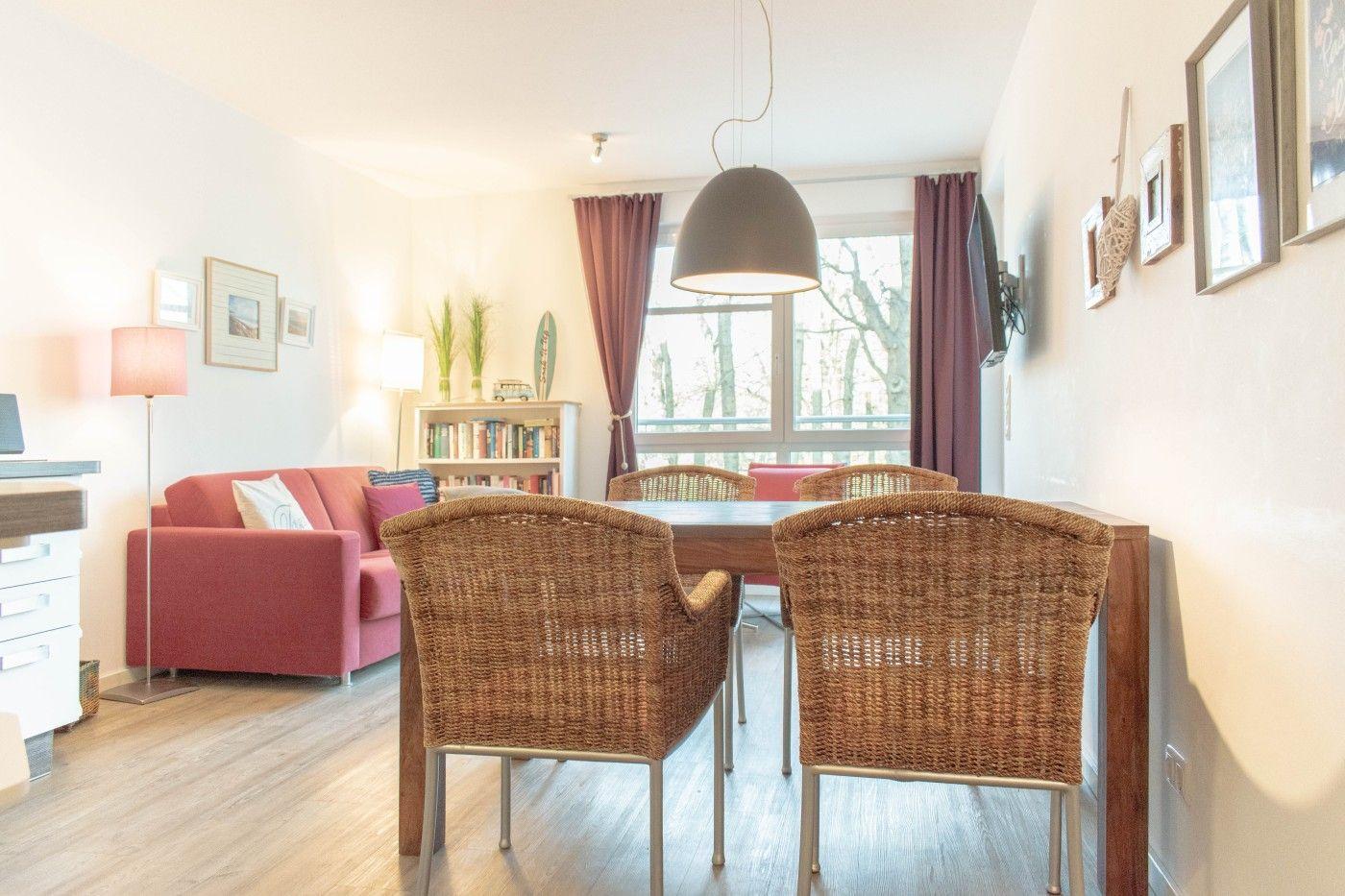 Esszimmer mit Esstisch und Stühlen, Wohnbereich mit Sofa und Fenster