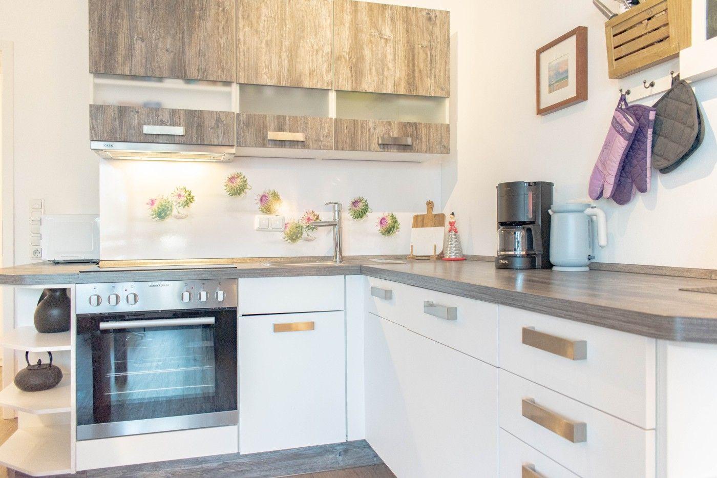 Küche mit Holzschränken, Edelstahlherd und Arbeitsplatte.