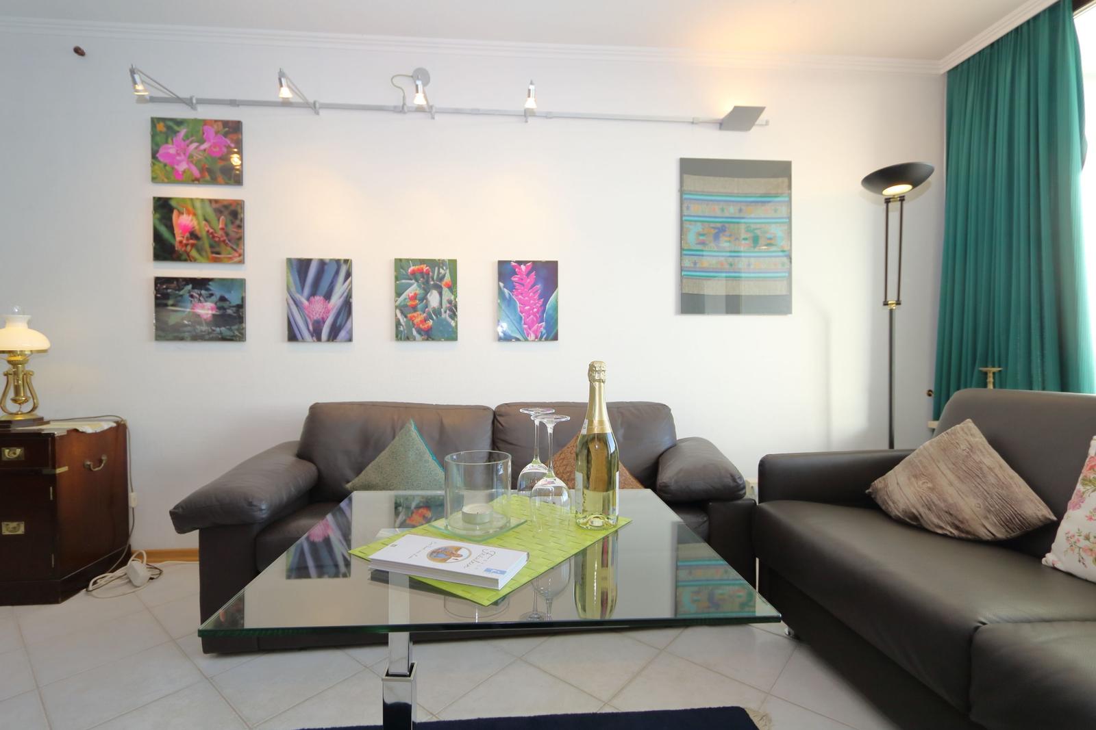 Living room with sofa, glass table, and wall art
