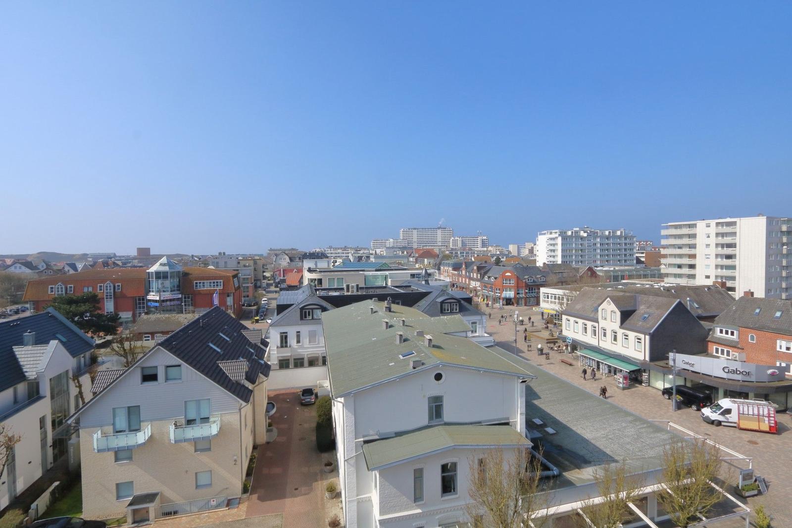 Panoramablick auf die Stadt mit Häusern und einem markanten Gebäude im Hintergrund.