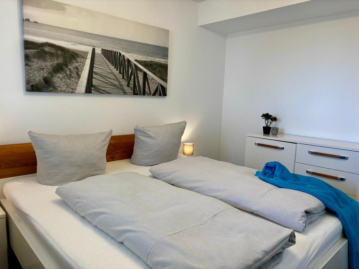 Schlafzimmer mit Doppelbett, Wandbild und Schrank.