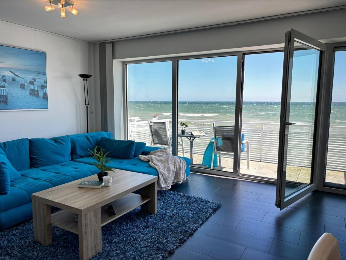 Wohnzimmer mit blauem Sofa und Blick auf das Meer.
