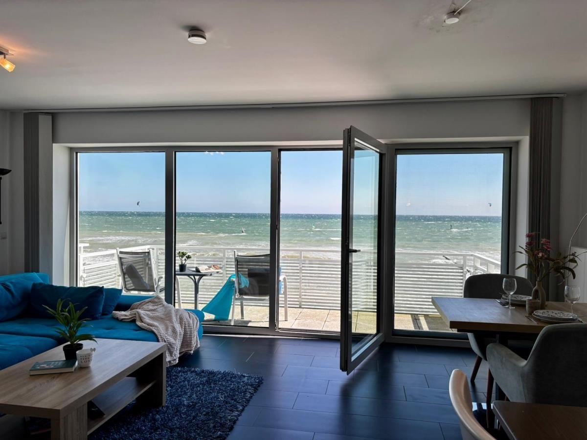 Wohn- und Essbereich mit Blick aufs Meer und Terrasse mit Liegestühlen.