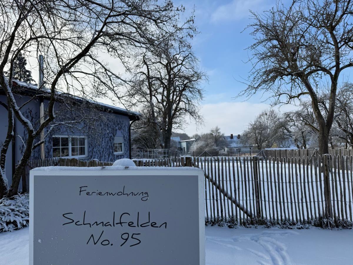 Ferienwohnung Schmalfelden No. 95 mit Schneebedecktem Grundstück und Holzzaun.