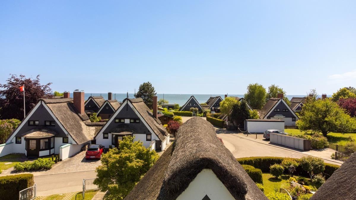 Dorf mit strohgedeckten Häusern und Blick auf das Meer.
