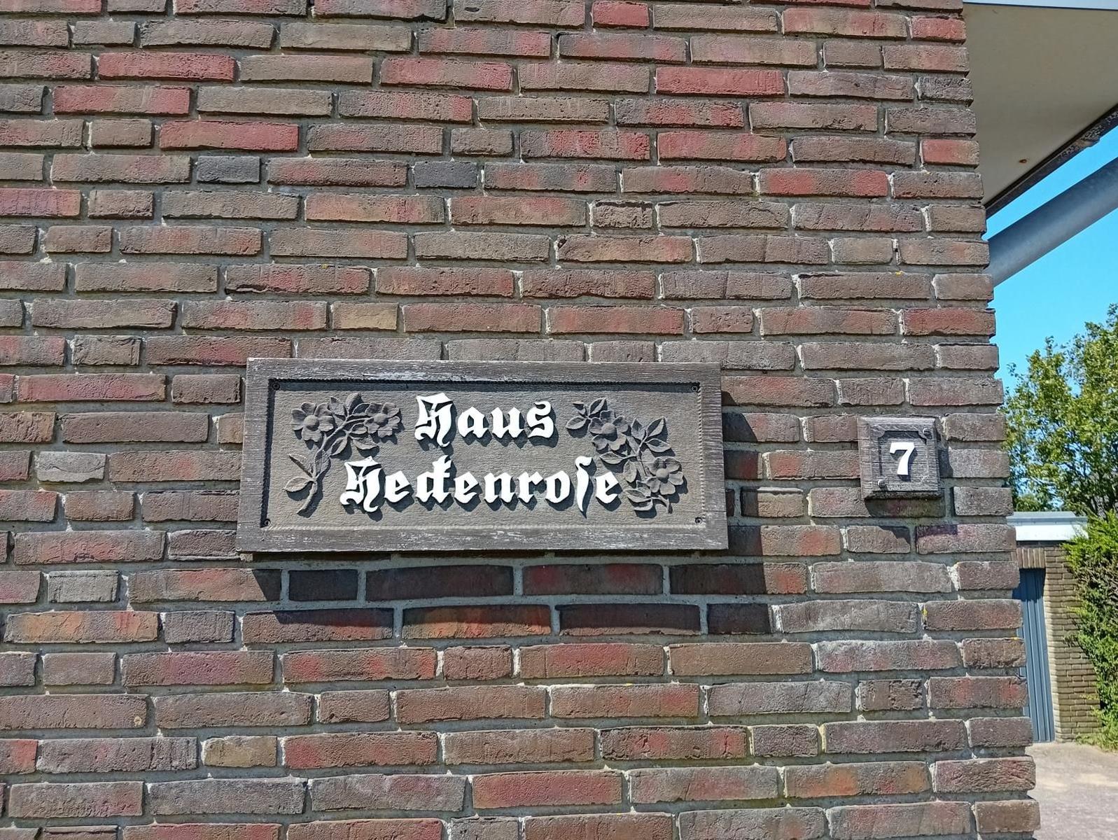 Haus Hedenrose mit Hausnummer 7 an einer Backsteinmauer.