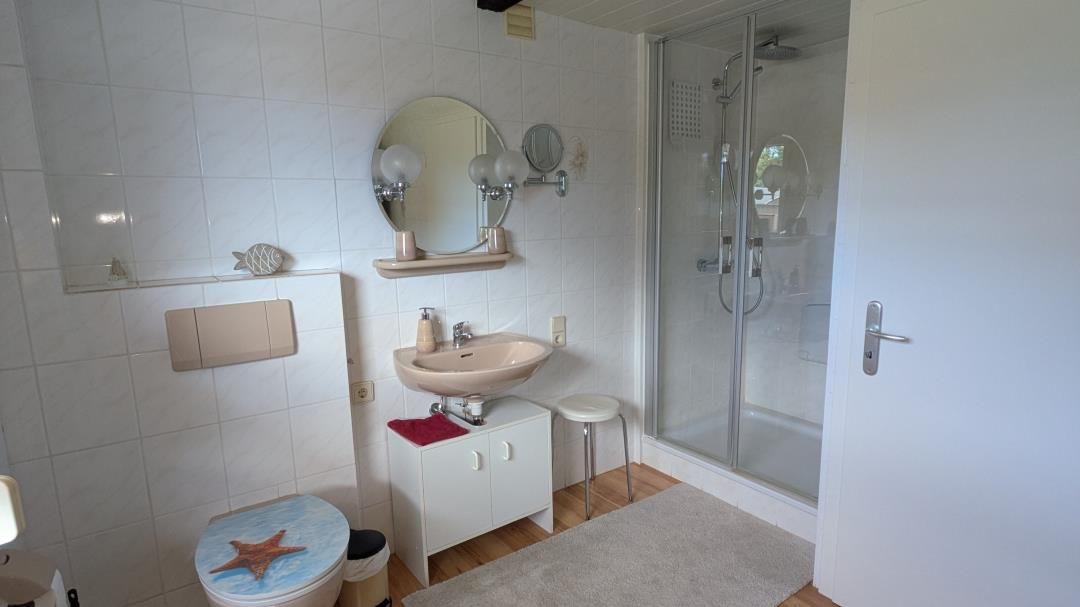 Badezimmer mit Dusche, Waschbecken und Toilette mit Sternenmotiv.