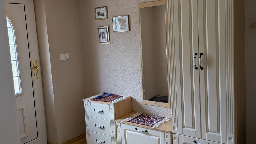 Schlafzimmer mit Kleiderschrank, Spiegel und dekorativen Bildern an der Wand.