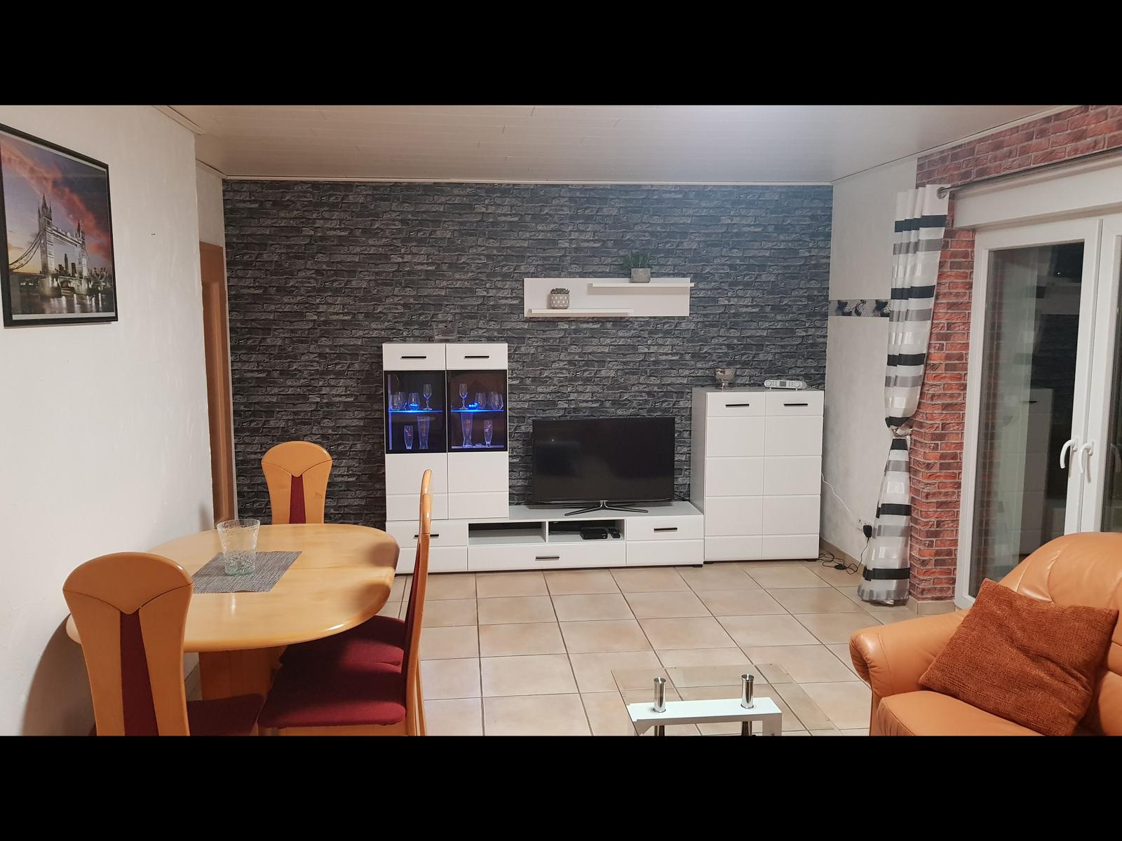 Living and dining area with TV, cabinet, and seating.