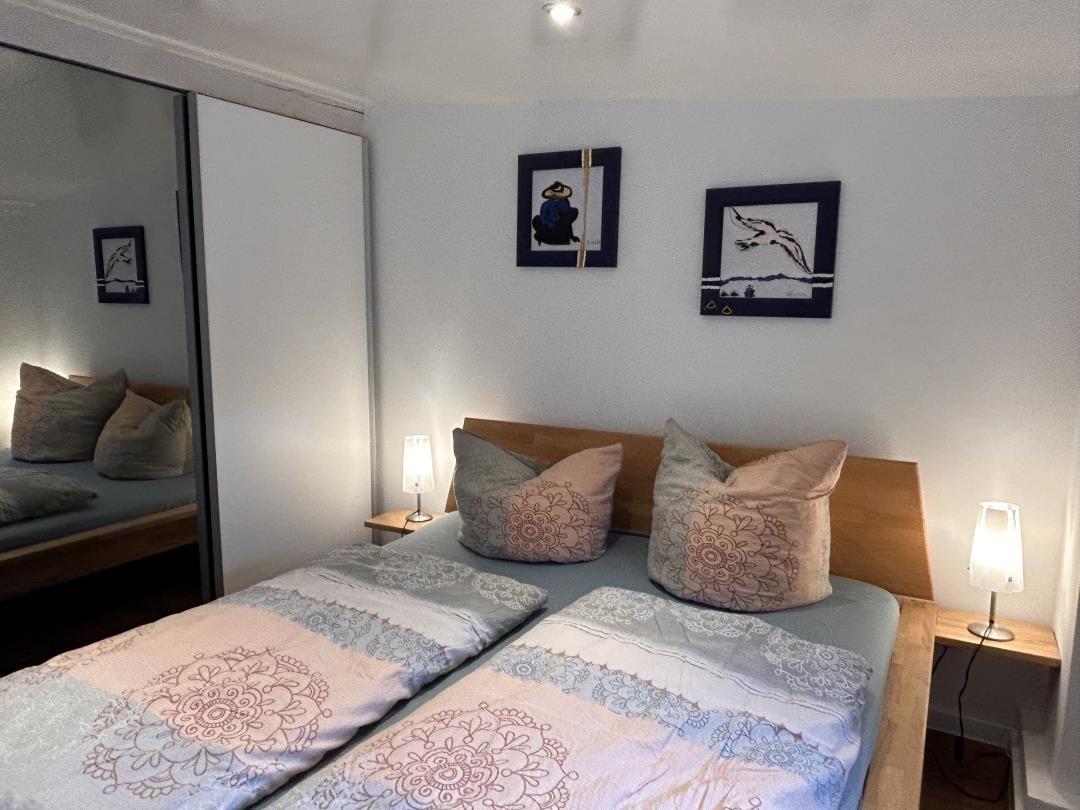 Schlafzimmer mit Doppelbett, zwei Nachttischen und Wandbildern.