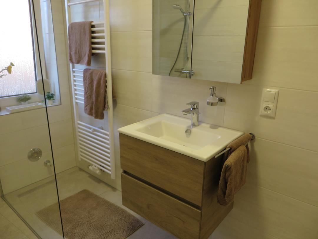 Bad mit Dusche, Waschbecken und Handtuchhalter.