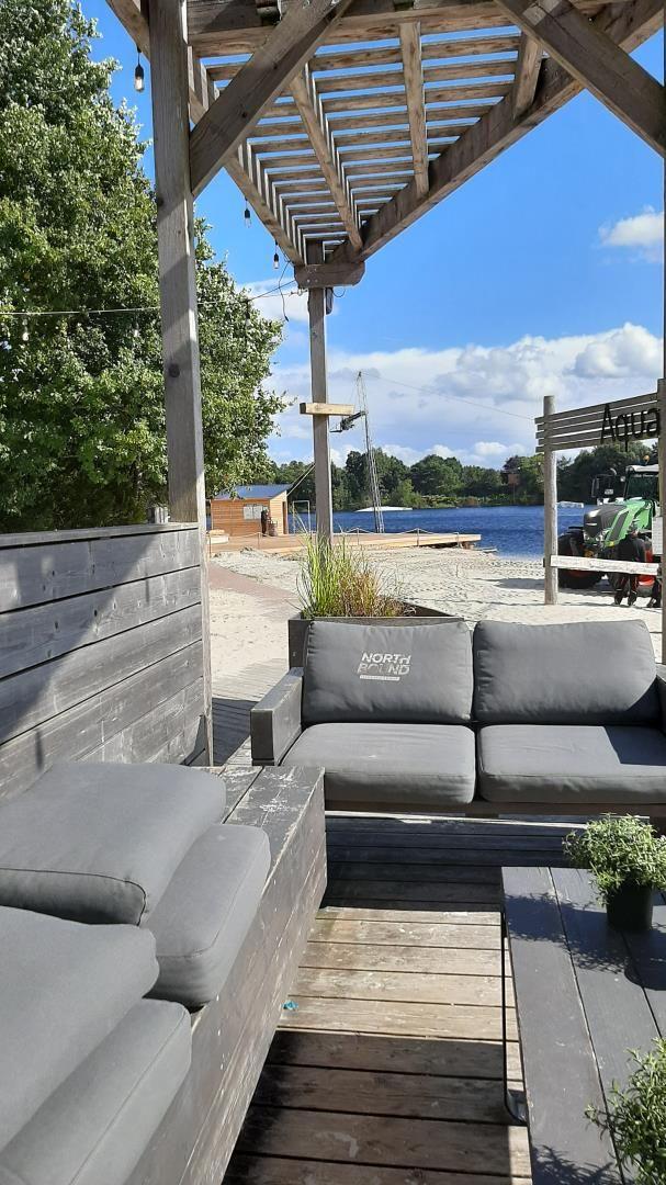Terrasse mit Sitzgruppe, Blick auf See und Strand.