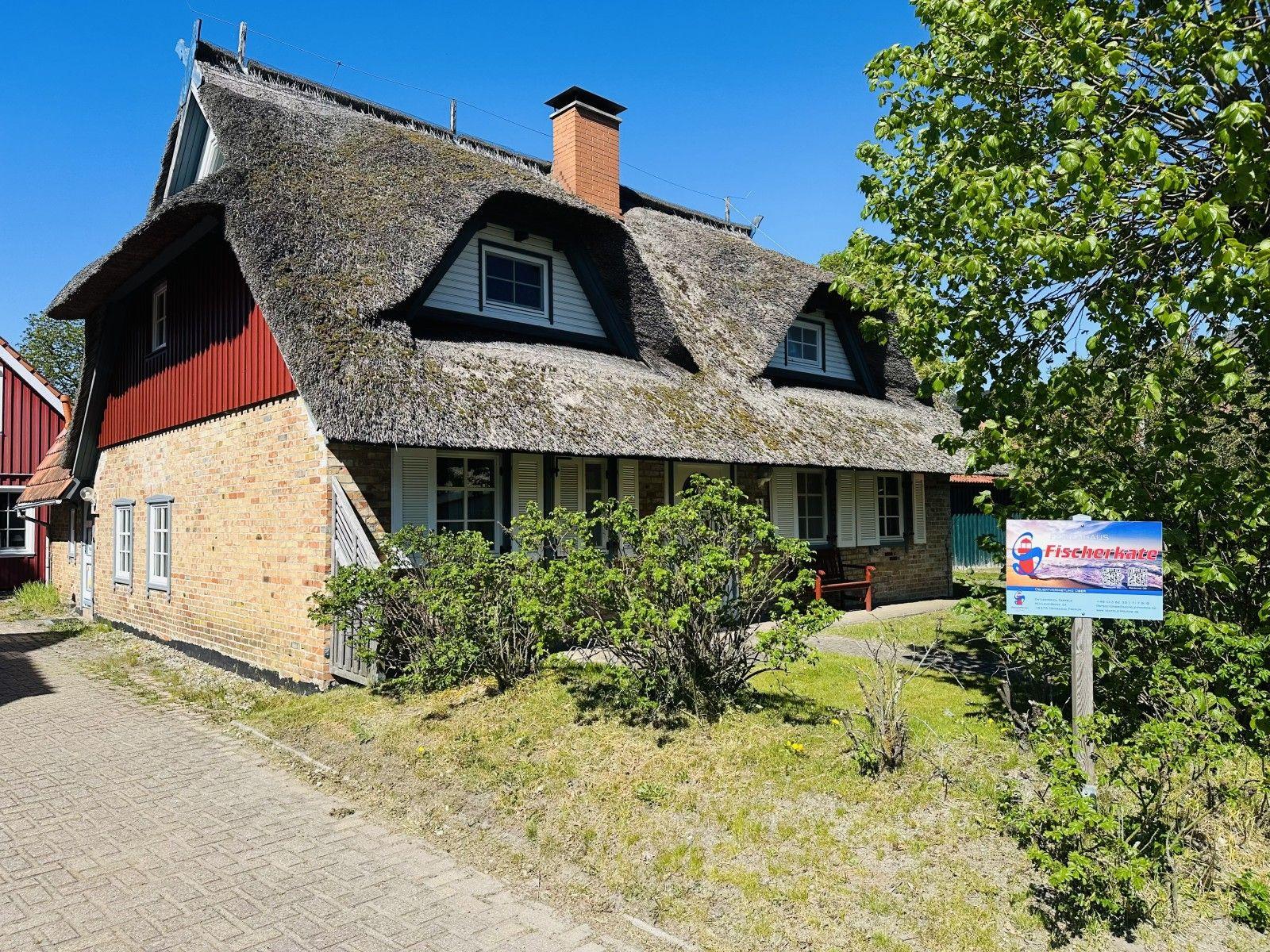 Fischerkate mit strohgedecktem Dach und Backsteinmauer