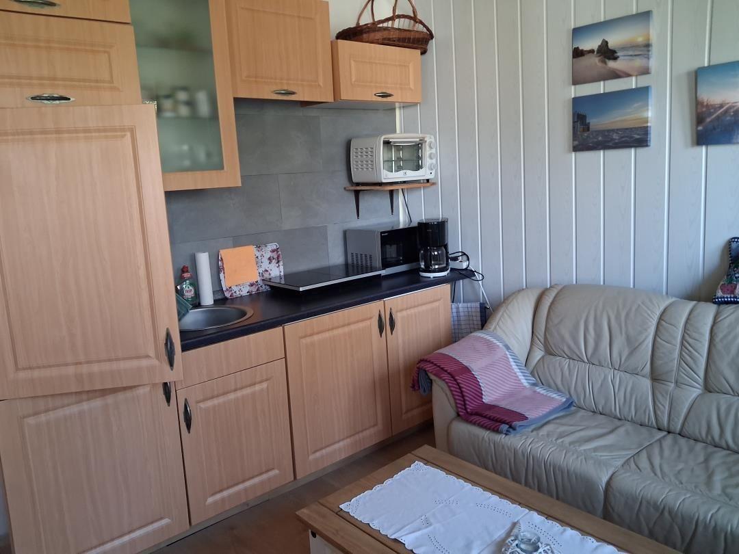 Kitchen with wooden cabinets and sofa in living area