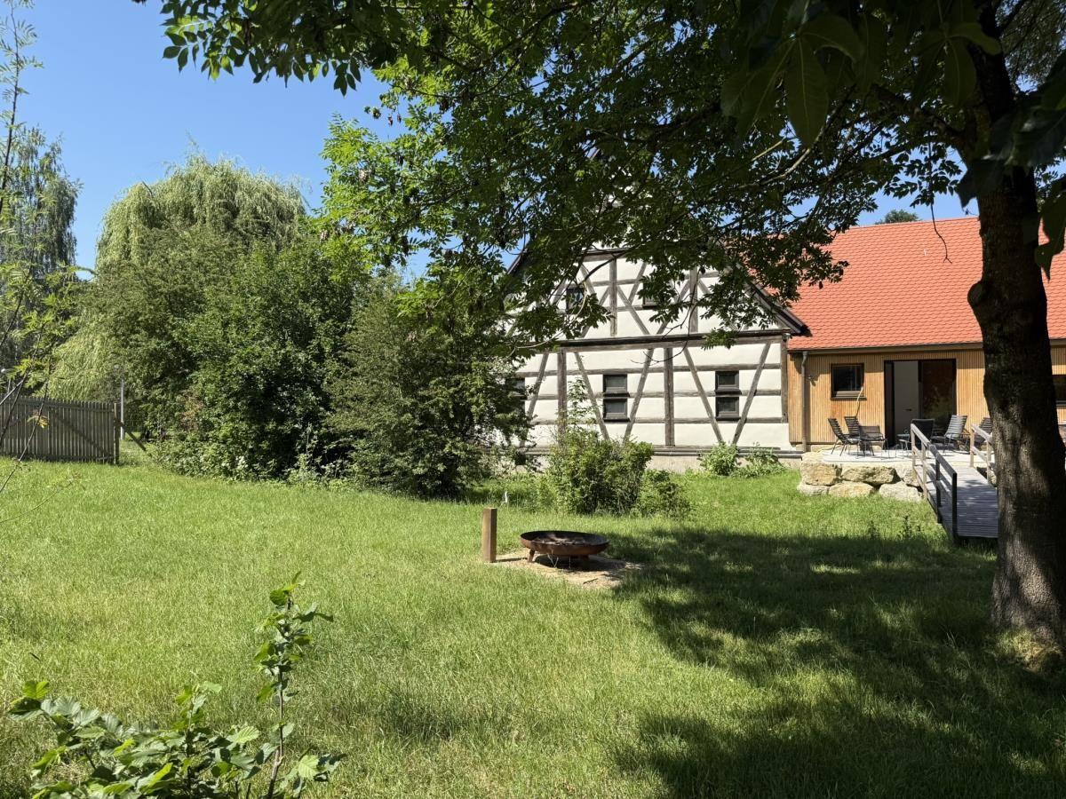 Haus mit Fachwerk, Terrasse und Grillplatz im Garten.