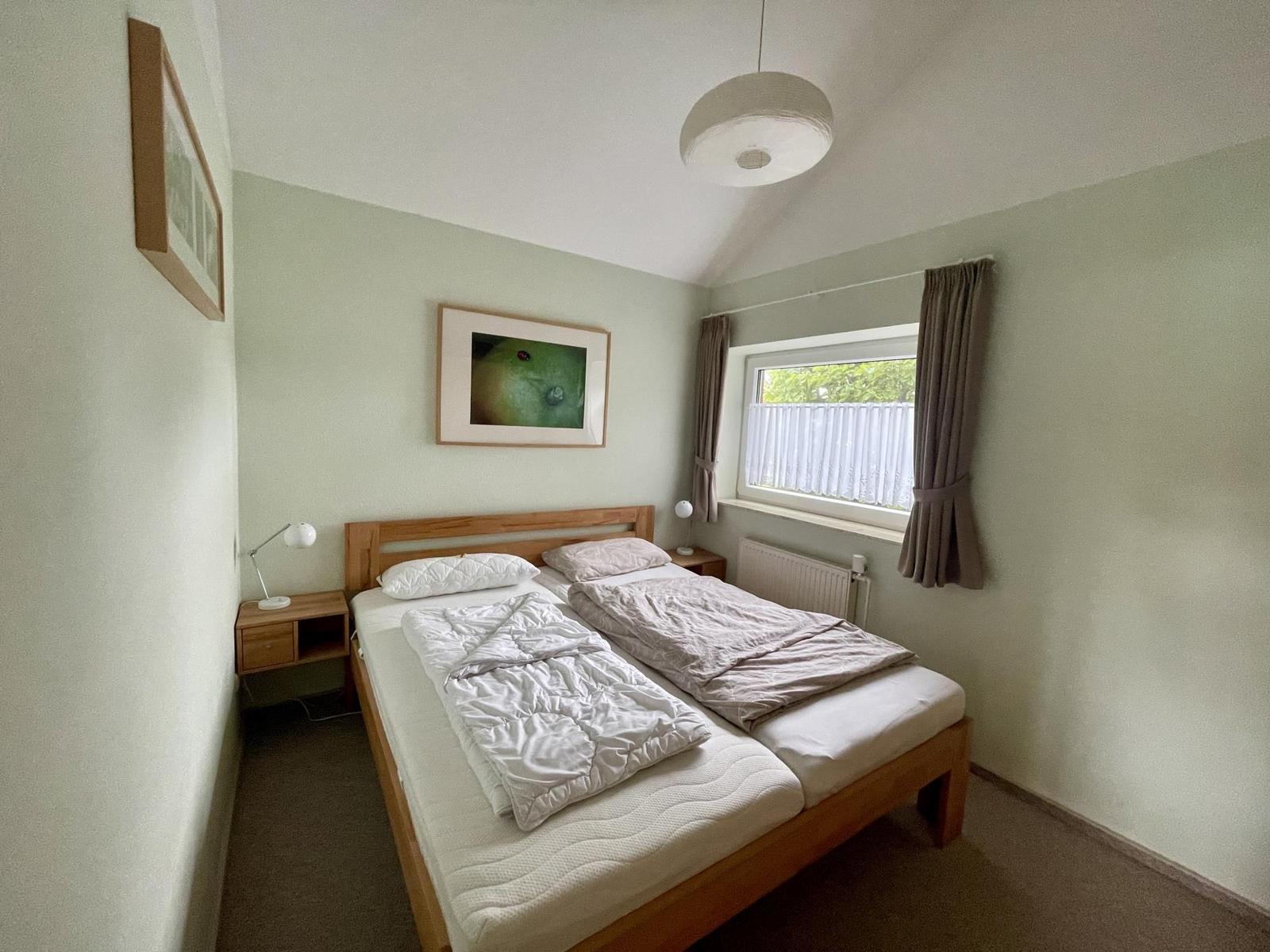 Bedroom with double bed, window, and two nightstands.
