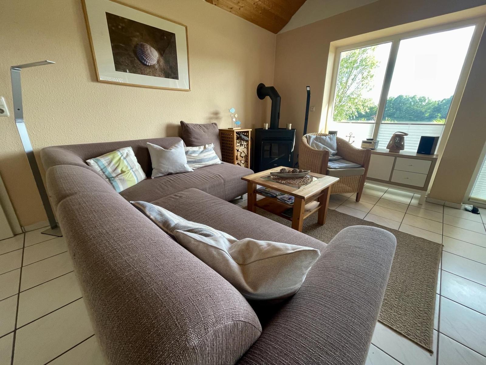Living room with sofa, fireplace, and view of the lake.