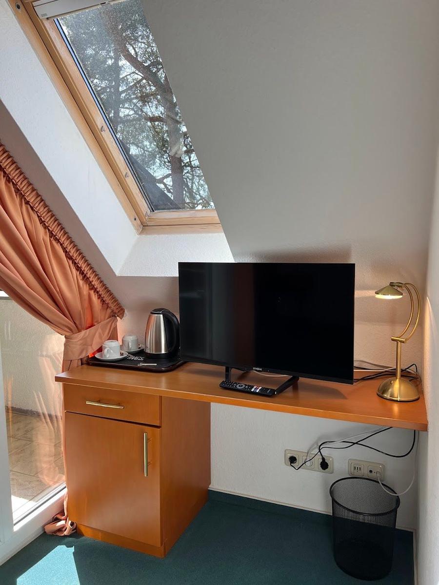 Schlafzimmer mit TV, Kaffeemaschine und Dachfenster.