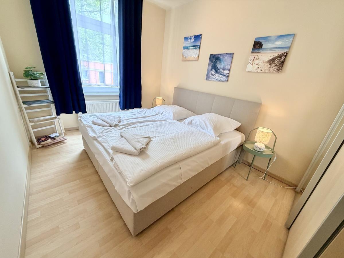 Schlafzimmer mit Doppelbett, Fenster und Wandbildern