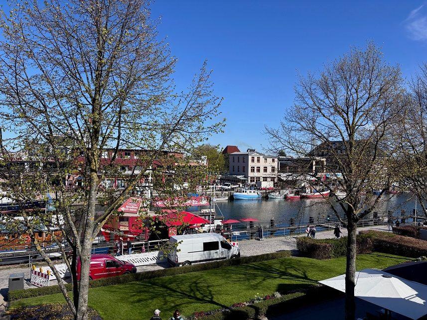 Panoramablick auf Hafen mit Booten und roten Markisen.