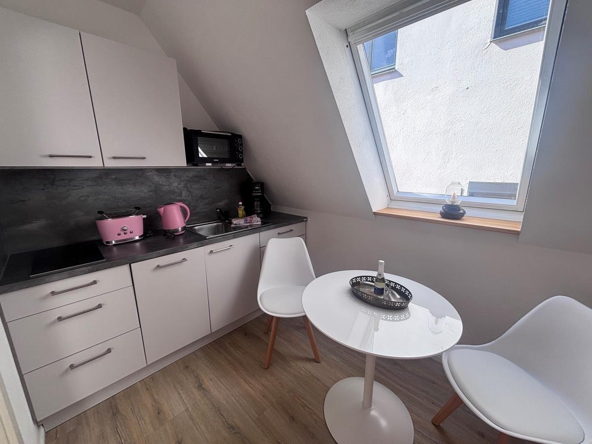 Küche mit Essbereich, pinken Geräten und Dachfenster
