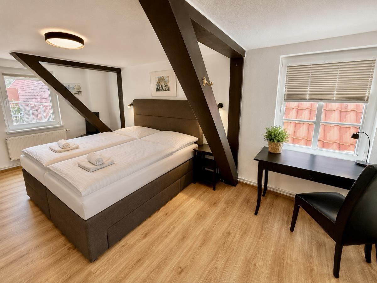 Schlafzimmer mit Doppelbett, Schreibtisch und Fenster mit Blick auf Dach