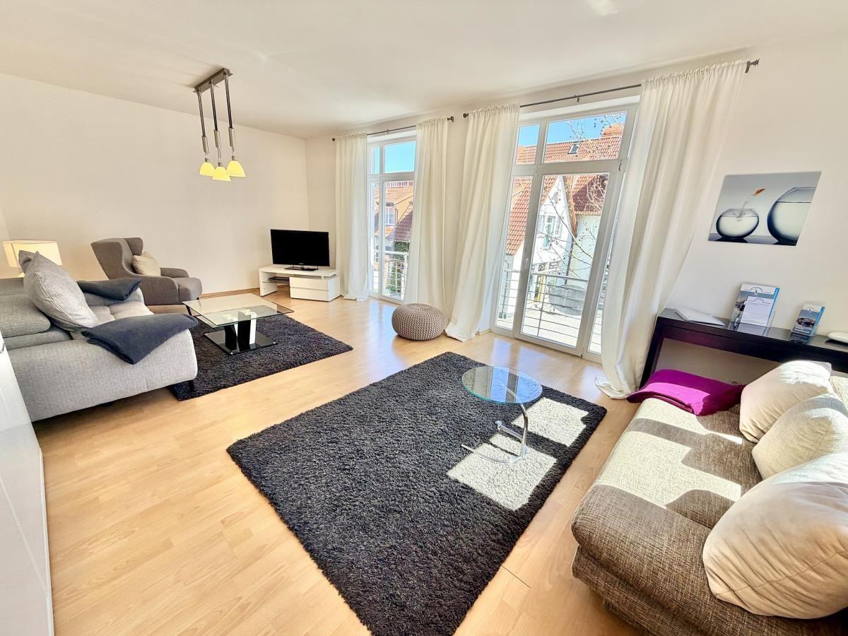 Wohnzimmer mit Sofa, Couch, Teppich und Fenster zur Terrasse.