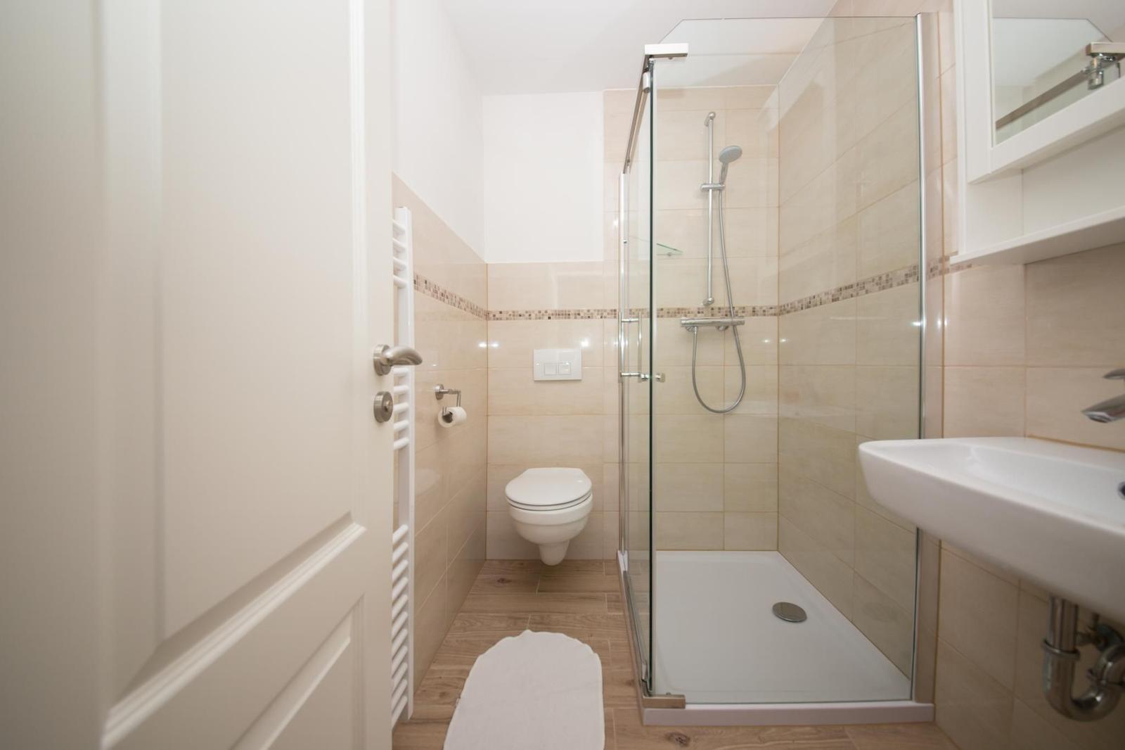 Badezimmer mit Dusche, Toilette und Waschbecken