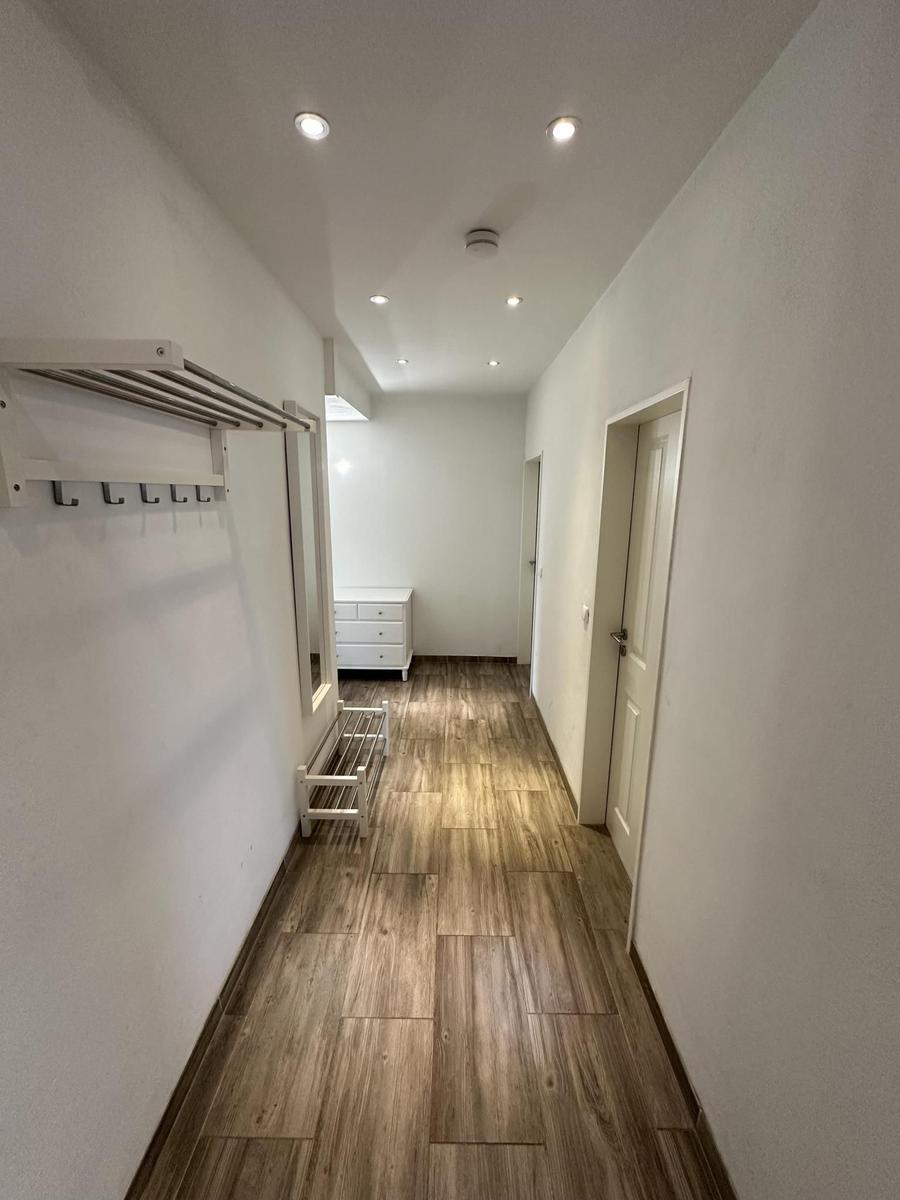 Flur mit Holzboden, Garderobe und Tür zu einem Zimmer.