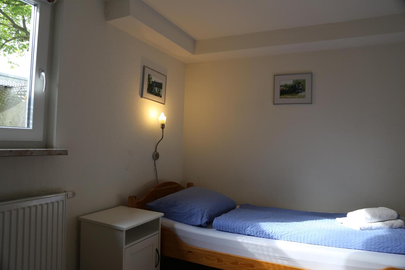 Ein Schlafzimmer mit einem Bett, einem Nachttisch und einer Wandlampe.