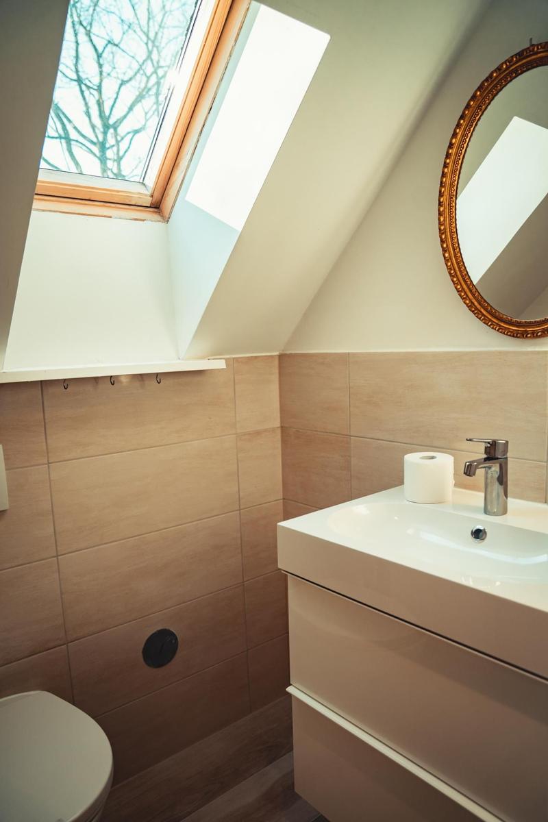 Badezimmer mit Dachfenster, Spiegel und Waschtisch