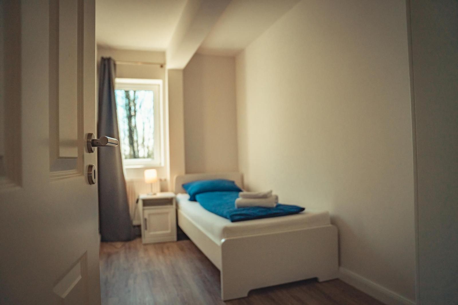 Ein Schlafzimmer mit einem Bett, einem Nachttisch und einem Fenster.