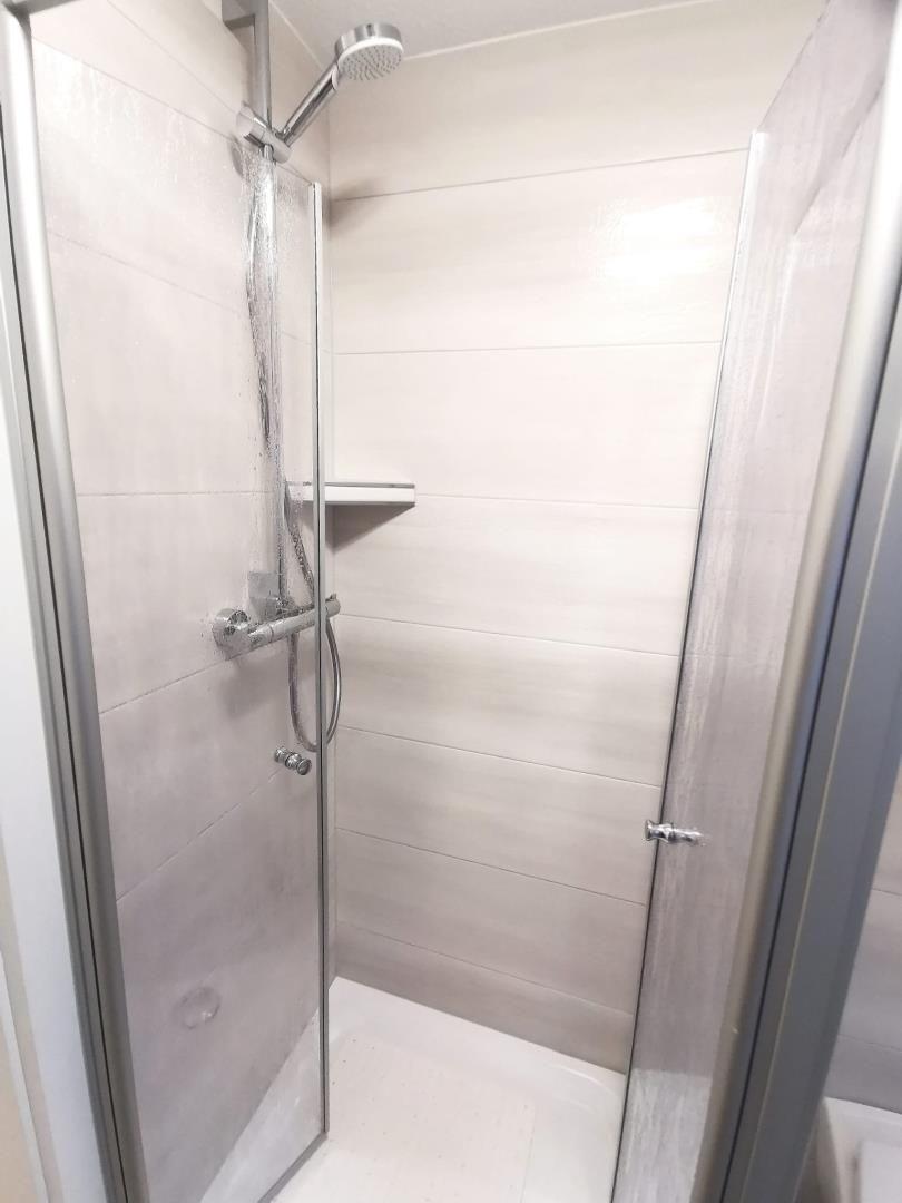 Dusche mit Glaswand und Duschbrause